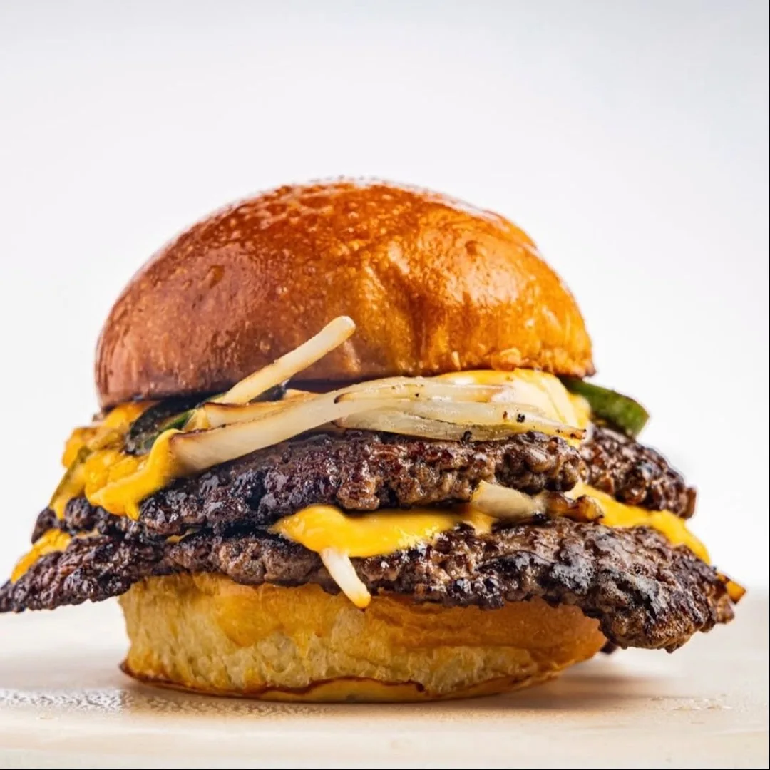 Stacked double cheeseburger with melted cheese and onions