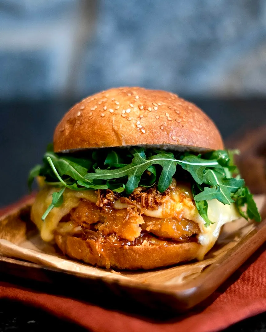 Chicken burger with arugula on wooden board