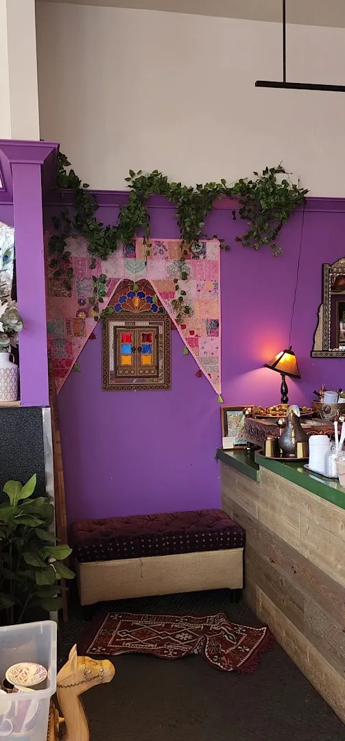 Interior corner with purple walls, ornate door art, climbing greenery