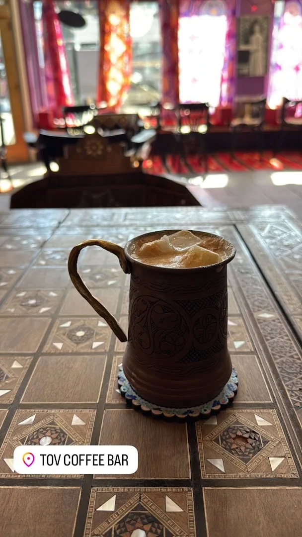 Ornate coffee cup on geometric tile floor with purple backdrop