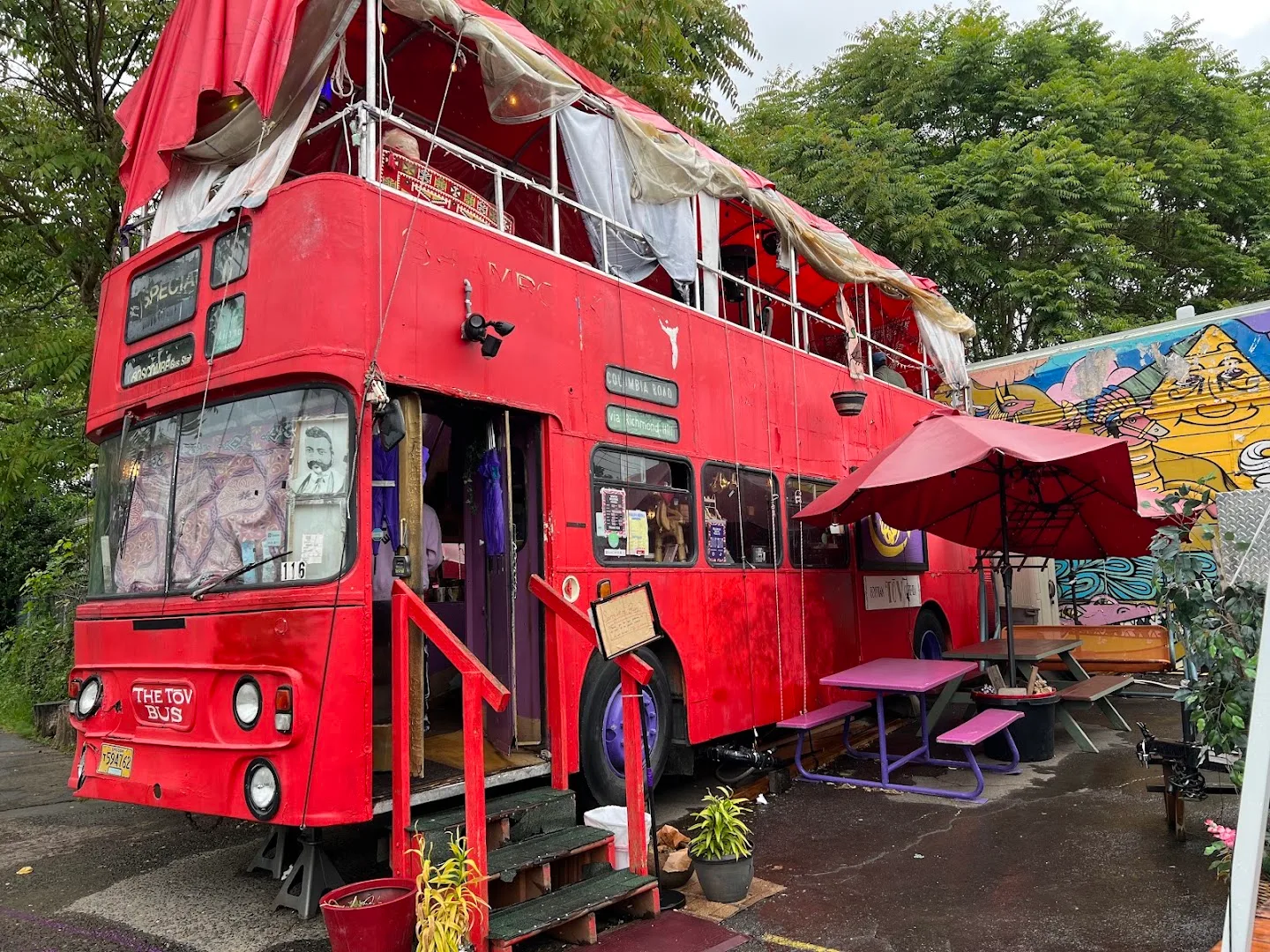 Red double-decker bus exterior converted into seating space